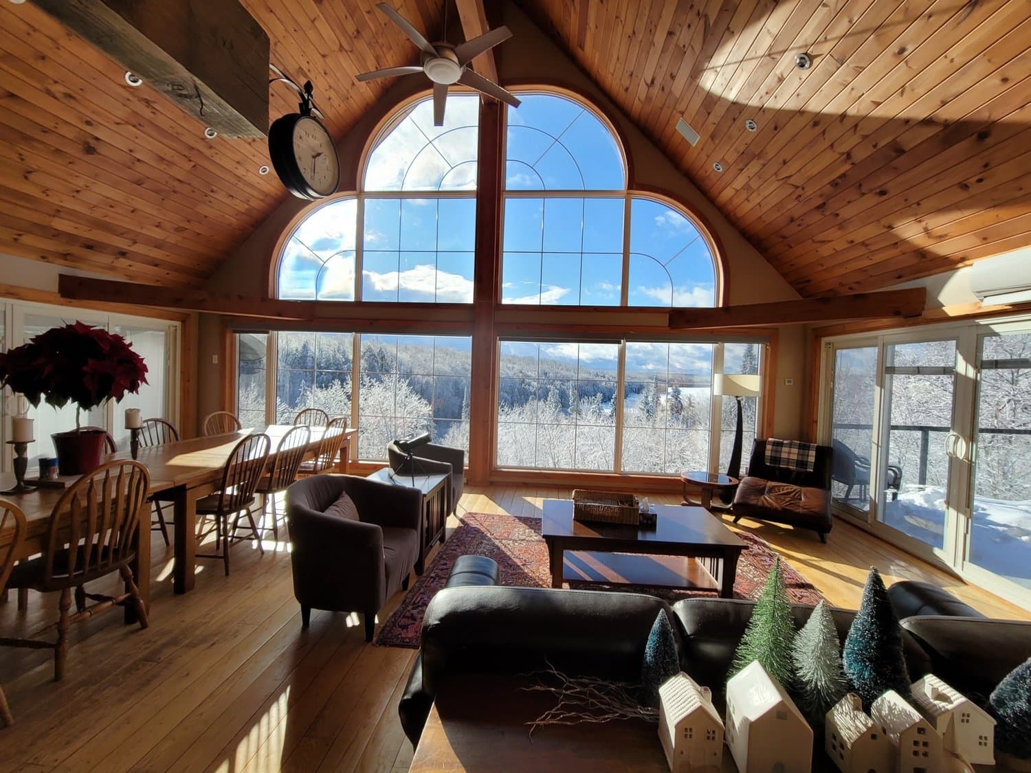 Great room with arched windows overlooking the treetops