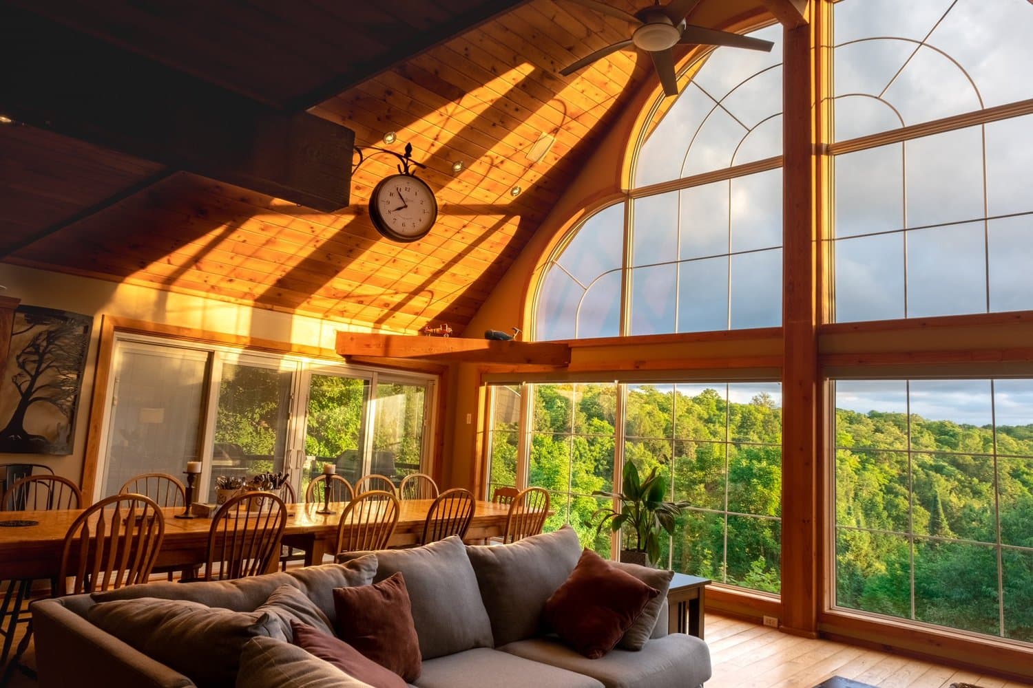 Sunlit great room with vaulted ceiling and wall of windows