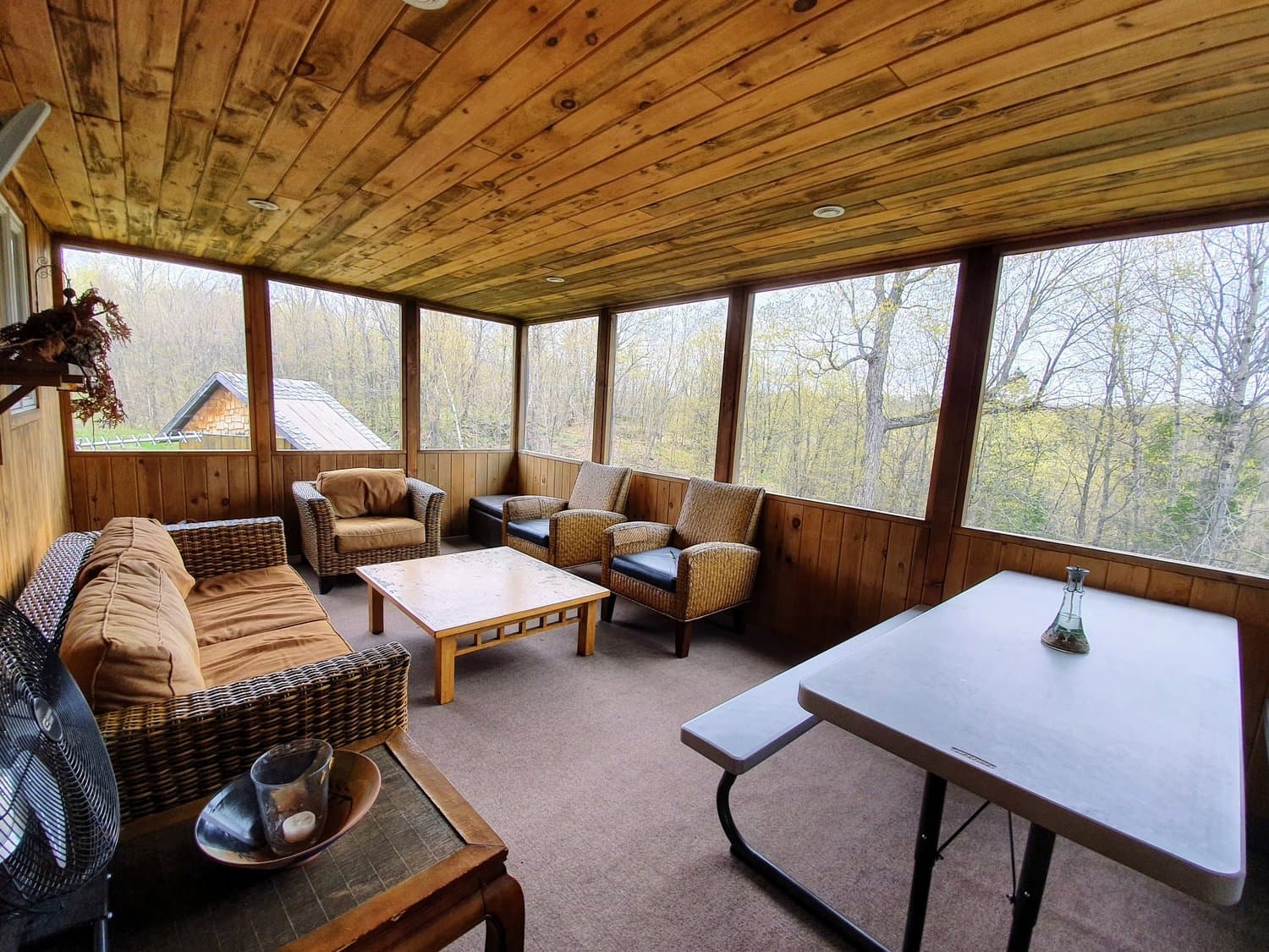 Screened porch with seating and a picnic table