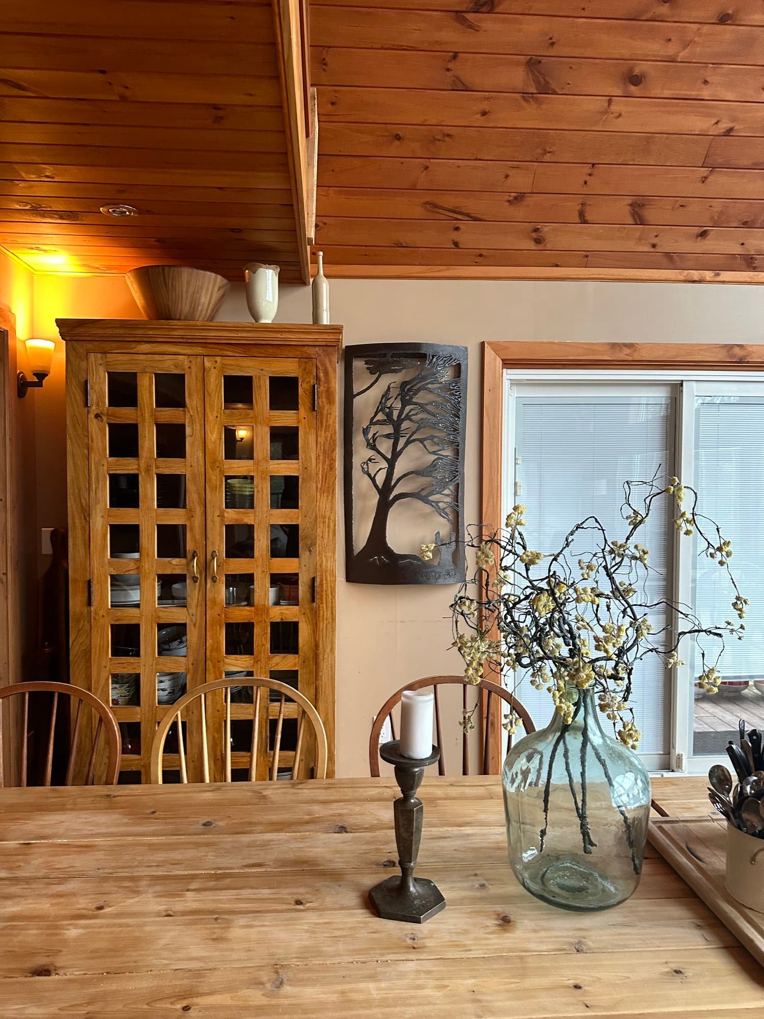 Dining table with fresh flowers beside the wine cabinet