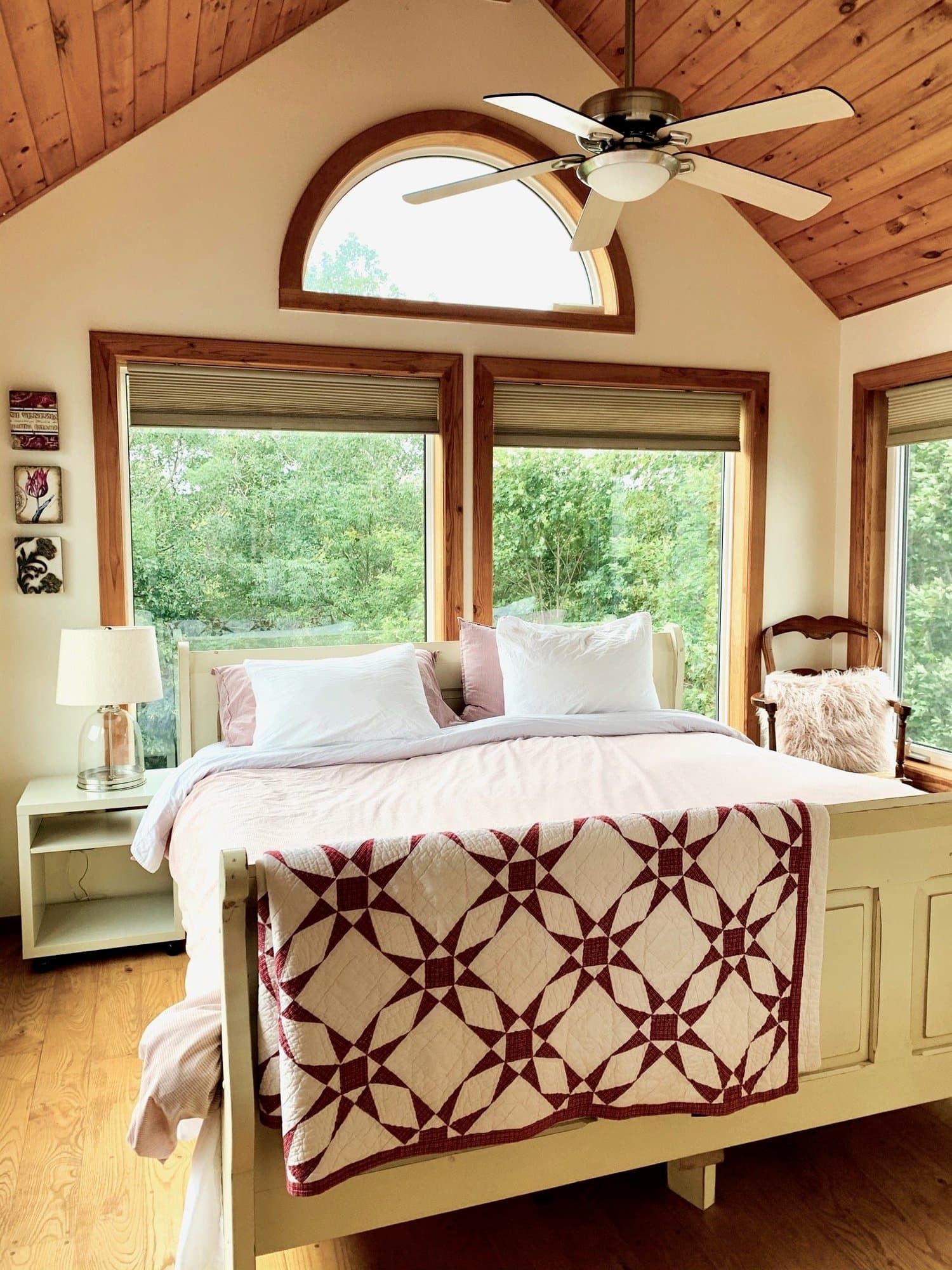 Master bedroom with arched window and quilt