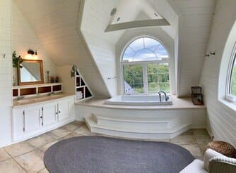 Master bathroom with soaker tub under an arched window