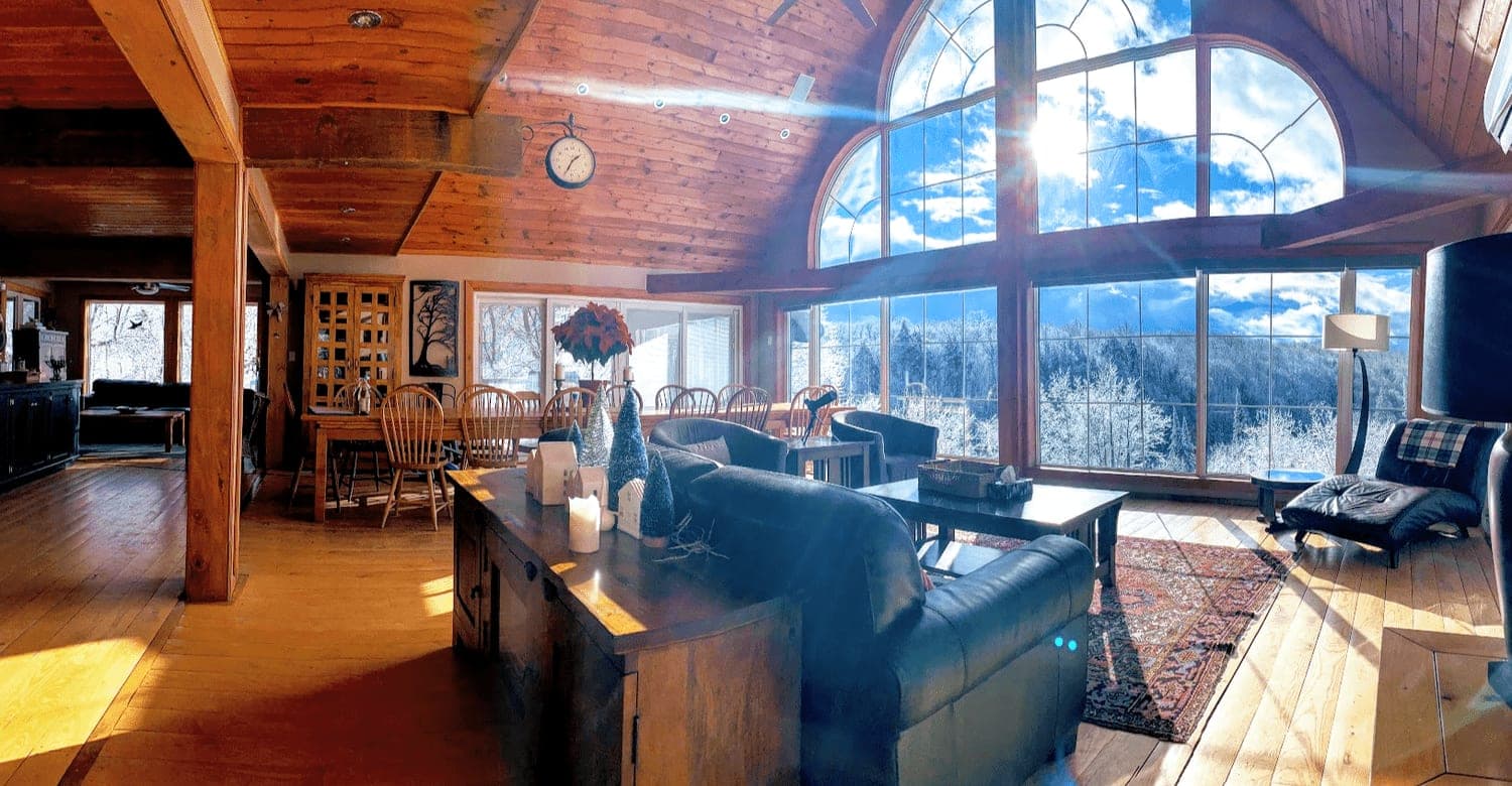 Great room with a wall of windows and a winter view