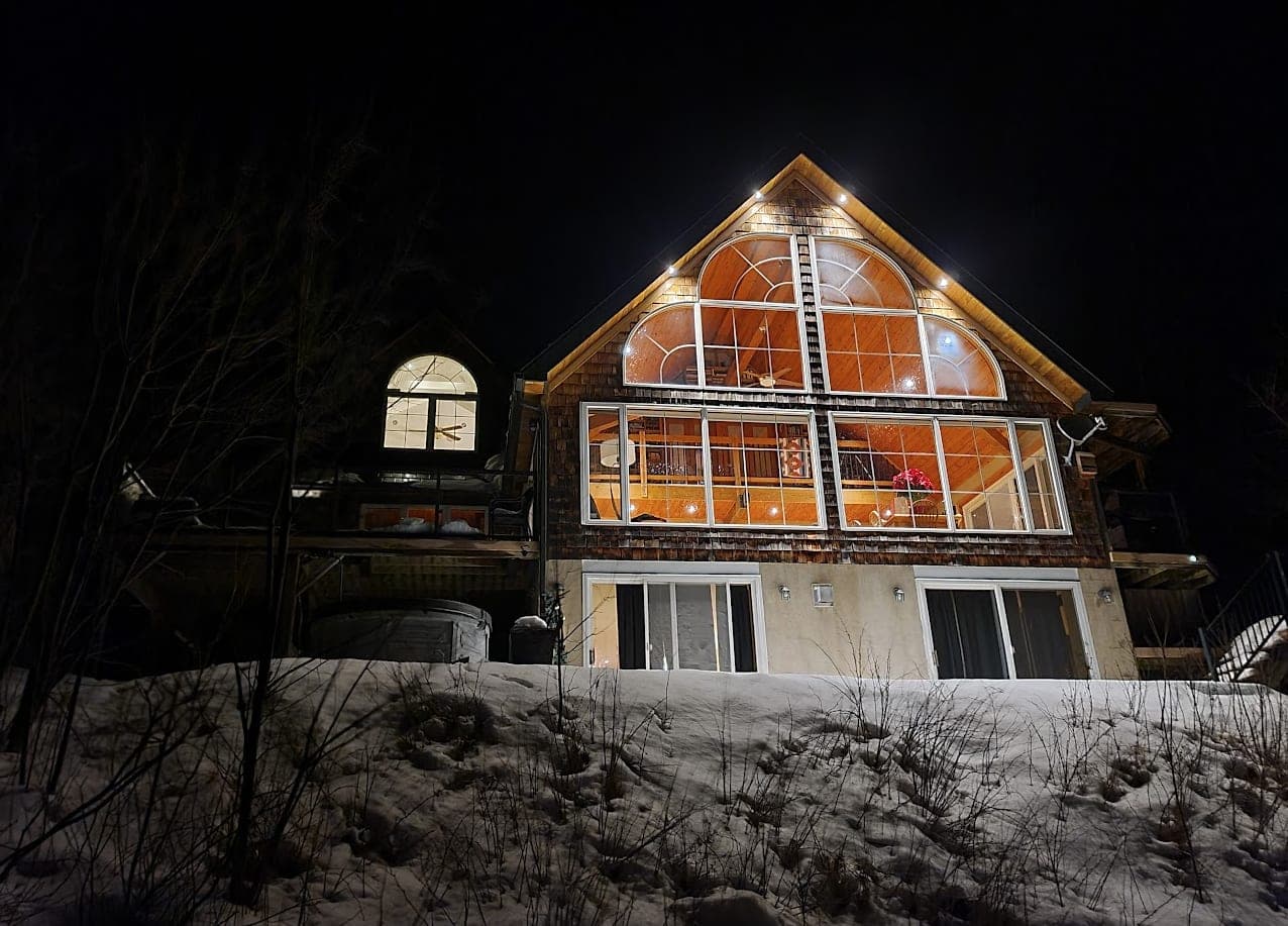 The cottage lit up on a winter night