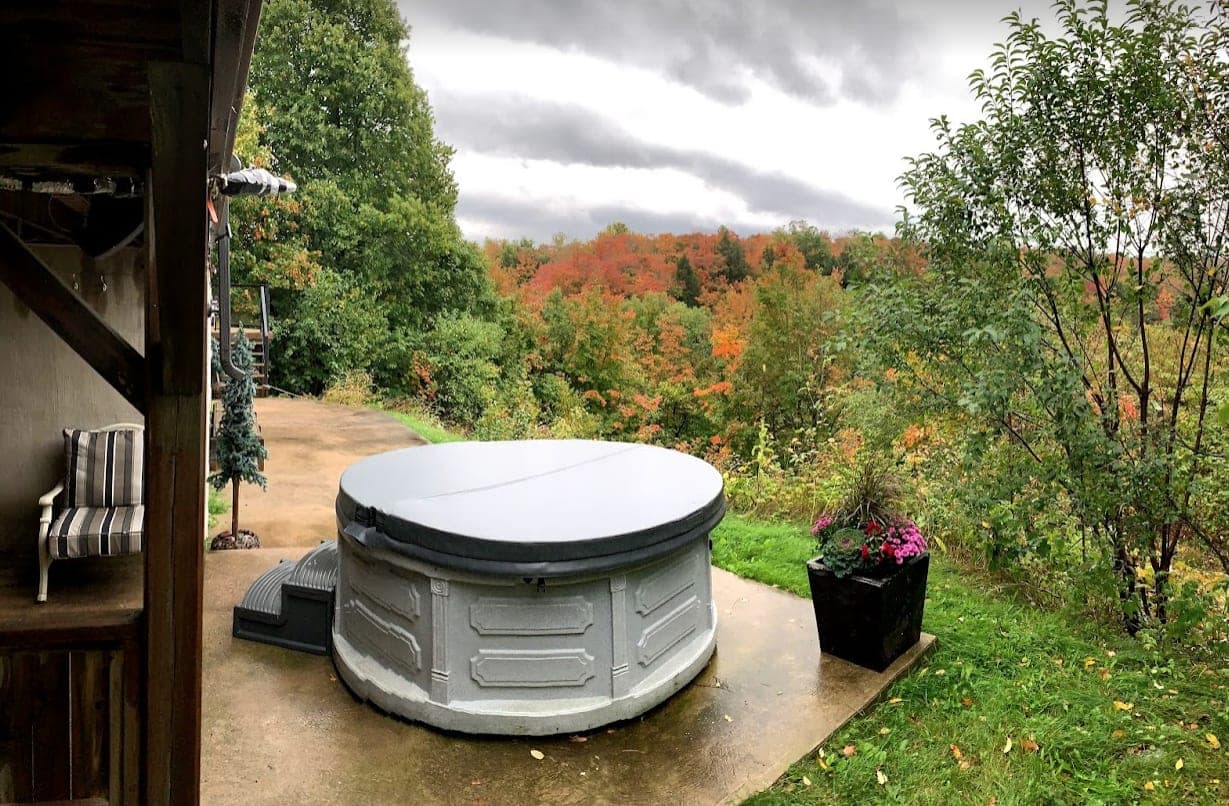 Hot tub on the patio with fall colours behind