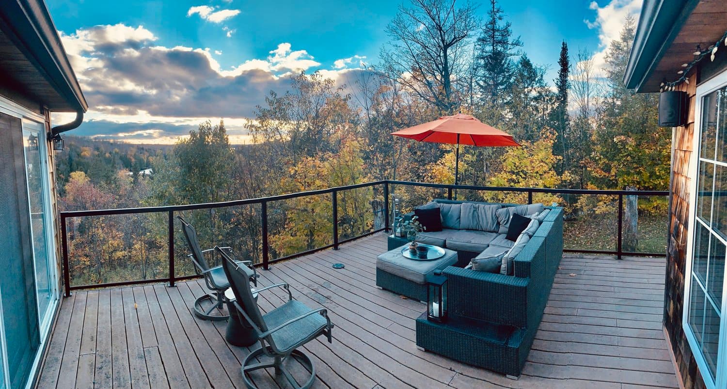 Deck with an outdoor sectional overlooking the fall forest