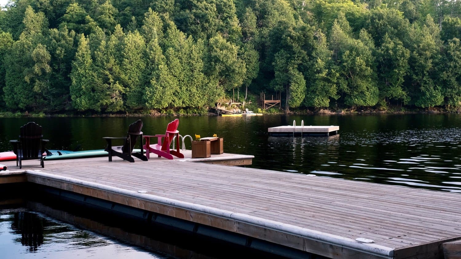Large dock with Muskoka chairs and a swim raft