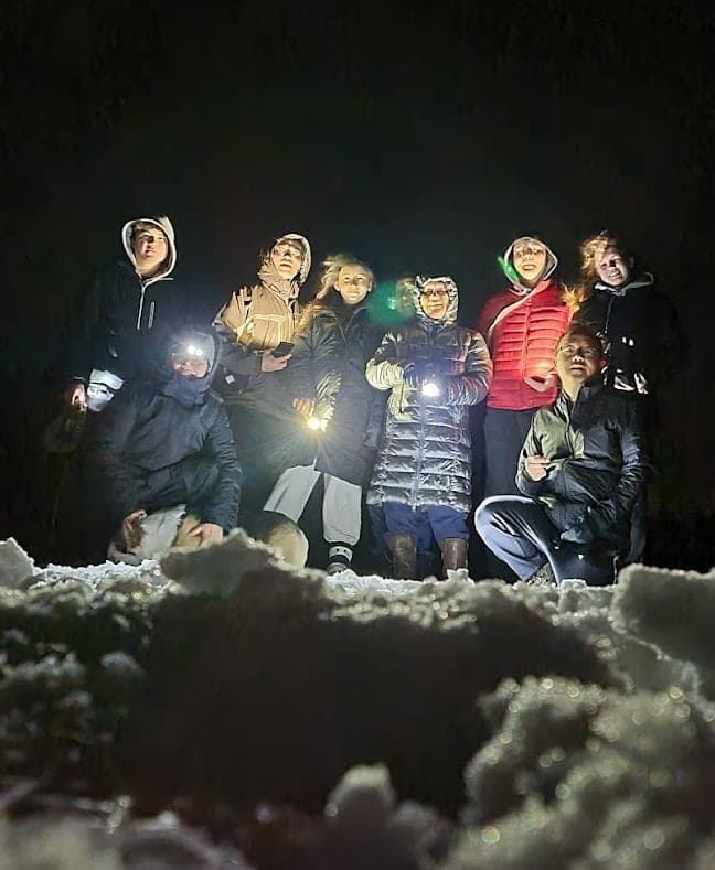 Group with headlamps on a winter night
