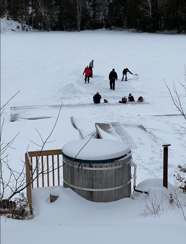 Wood-fired hot tub beside the frozen lake