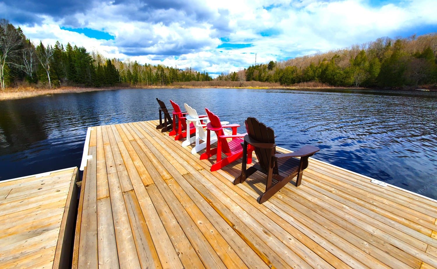 Red Muskoka chairs on the new dock