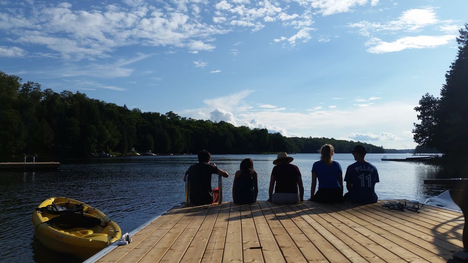 Friends sitting on the dock beside a kayak