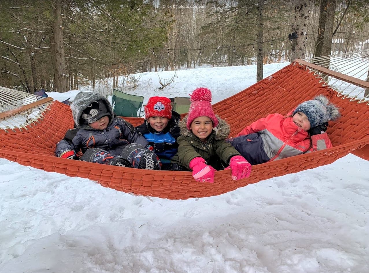 Children bundled up in a hammock in the snow