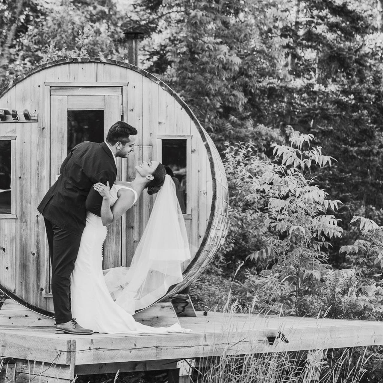 Couple kissing beside the barrel sauna