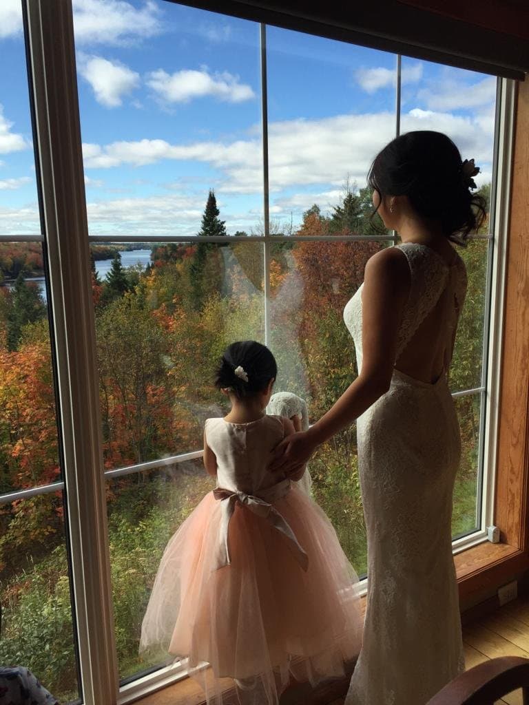 Bride and flower girl by the window