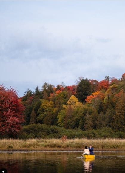 Canoe on the lake below the fall trees