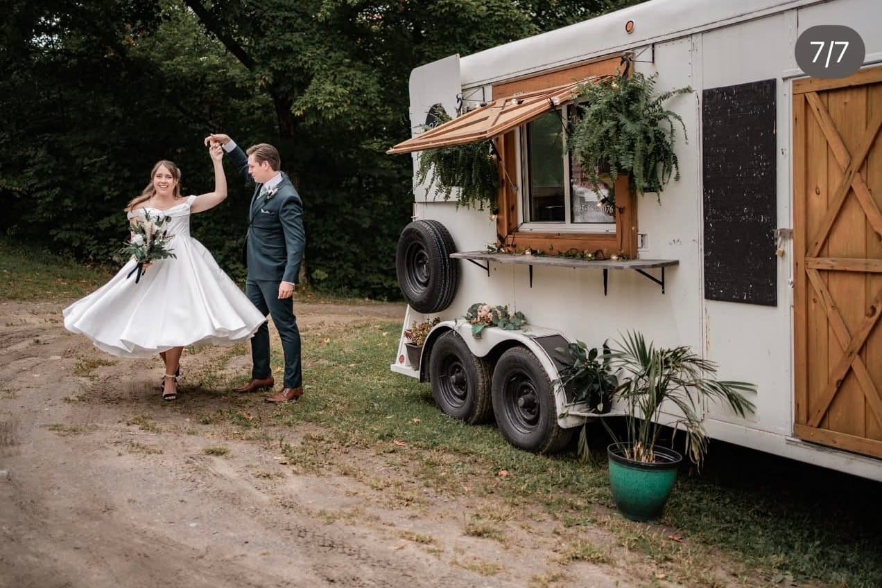 Bride twirling beside the bar trailer